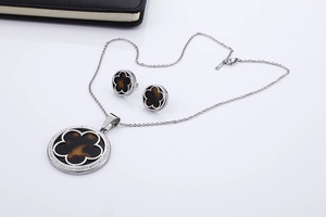 Detail of silver clover jewelry set featuring tortoiseshell resin and sparkling crystals