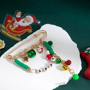 Détail d'une broche de Noël avec cloches et breloques sur une épingle dorée