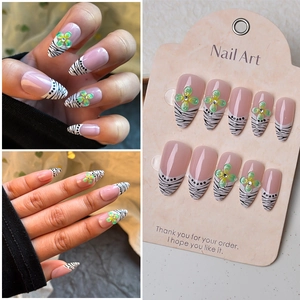 Almond press-on nails with zebra French tips and 3D green flower rhinestone accents