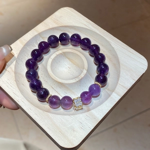 Detail of natural purple amethyst beaded bracelet with gold spacers and square zircon stone