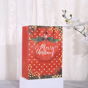 Close-up of a festive red Christmas paper gift bag with white polka dots and rope handles