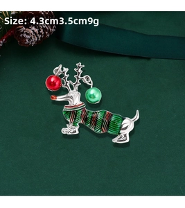 Detail view of silver dachshund brooch with reindeer antlers, red and green enamel, 4.3x3.5cm