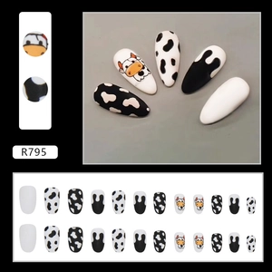 Cute almond press-on nails with black and white cow patterns and cartoon cow art