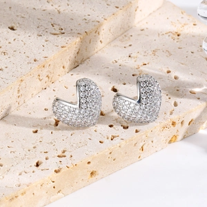 Detail of silver heart earrings with micro-pave zirconia on a natural stone base