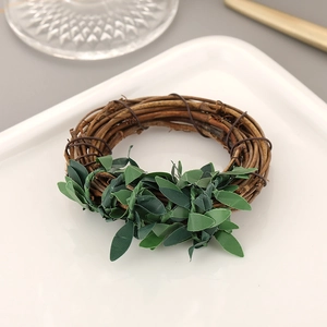 Macro shot of hand-woven rattan napkin ring with dark green leaves on white ceramic plate