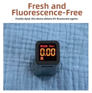 Detail of blue cotton gauze fabric showing zero fluorescent agent test result on detector