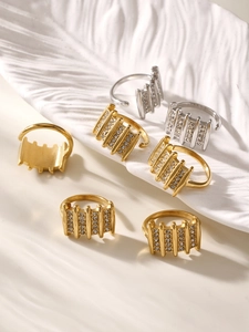 Detail of adjustable zircon rings in gold and silver finish on ceramic tray