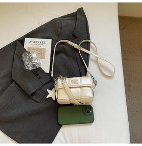 Détail du sac bandoulière tressé blanc cassé avec pendentif étoile et sangle