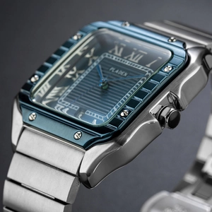 Macro detail of square blue dial with Roman numerals and silver metal strap of the watch