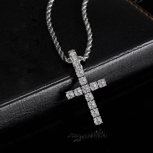 Close-up of iced out silver cross pendant with cubic zirconia and twisted rope chain