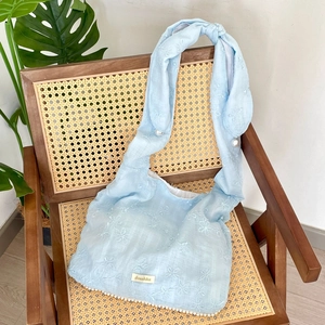 Detail der Blumenstickerei auf hellblauer Chiffon-Tasche mit Perlen-Verzierungen