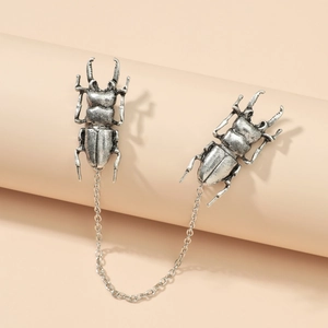 Detail view of retro silver beetle collar pins with decorative metal connecting chain