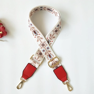 Detail of adjustable floral strap with red leather ends and golden metal hardware clips