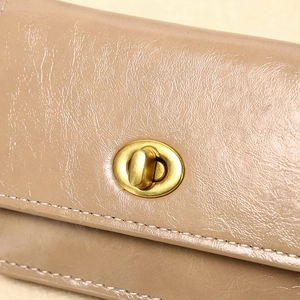 Detailansicht des goldenen Drehverschlusses und khaki Ledertextur der Geldbörse
