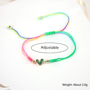 Adjustable rainbow woven cord bracelet with emerald green zircon heart pendant details