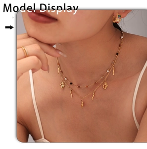 Close-up of double layer gold necklace with heart and horn pendants on a model