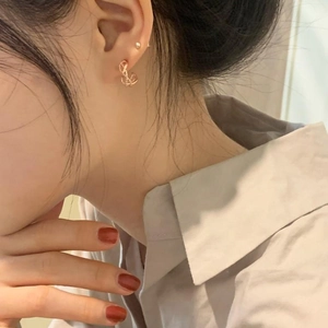Detailed side view of a model wearing minimalist twisted rope gold stud earrings