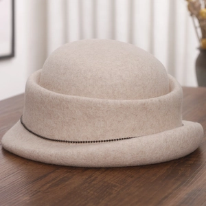 Close-up of oatmeal wool cloche hat with rolled brim and delicate black beaded chain