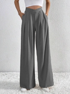 Detail of grey wide-leg trousers featuring a pleated texture and stylish V-shape waistline