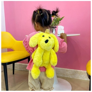 Child wearing bright yellow cartoon dog plush backpack with soft faux fur texture