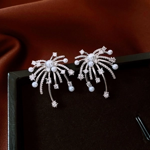 Detailed shot of silver firework earrings with sparkling zircons and white pearls