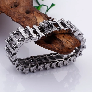 Detail of mechanical dragon link bracelet with carved head clasp on driftwood