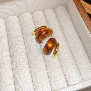 Macro shot of Maillard geometric amber resin earrings with gold metal in a jewelry box