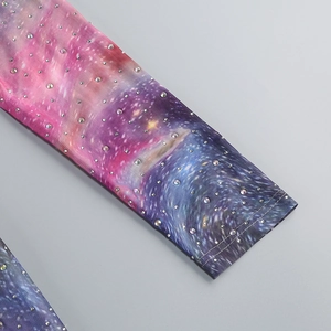 Gros plan du tissu en maille avec imprimé dégradé et strass brillants sur la manche