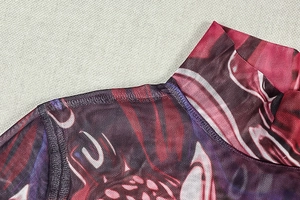 Detail of high neck mesh dress featuring red and purple abstract print and fine texture