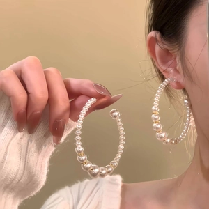 French vintage C-shaped pearl earrings with gold beads shown on model in warm lighting