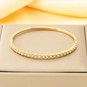 Détail du bracelet en acier titane doré avec cristaux blancs et fermoir à charnière