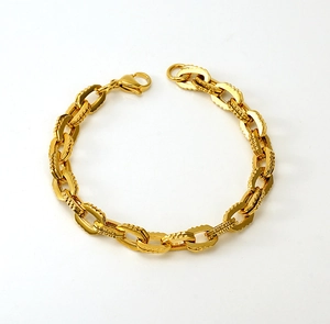 Détail macro du bracelet à maillons dorés avec motif ovale texturé et fermoir mousqueton