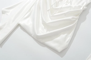 Détail du tissu en satin blanc avec texture plissée élégante et reflets soyeux