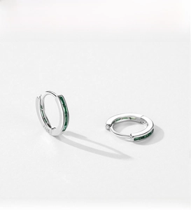 Macro shot of S925 sterling silver hoop earrings with rectangular green cubic zirconia
