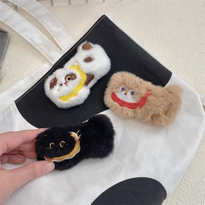 Detailed view of three cute plush animal brooches in white, brown, and black colors