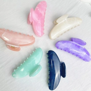 Set of six colorful marble pattern hair claws in pastel tones on white fabric