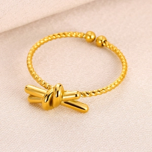 Detailed view of golden knot ring with twisted band design and polished mirror finish