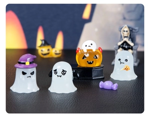 Close-up of Halloween resin figurines with glowing ghosts and pumpkin lanterns