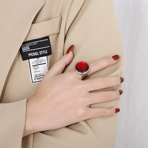 Detail of luxury ring with large round faceted red stone on silver titanium base