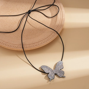 Detail of butterfly pendant necklace with sparkling rhinestones and black cord