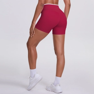 Detail of red high-waisted yoga shorts with white contrast trim and butt-lifting seam