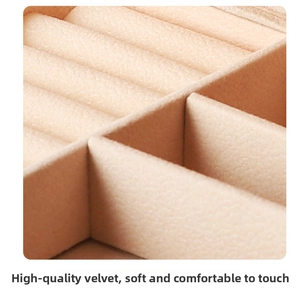 Macro detail of soft beige bead velvet interior showing ring slots and luxury texture