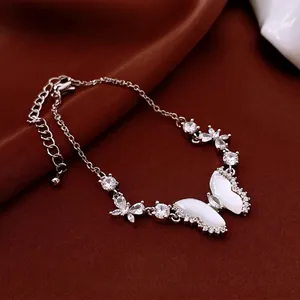 Elegant silver butterfly bracelet with sparkling zircon crystals on dark silk background