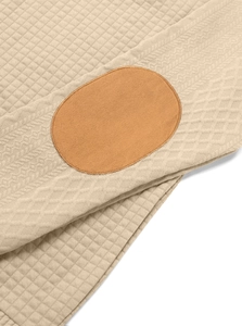 Close-up of waffle knit fabric with herringbone texture and suede elbow patch details