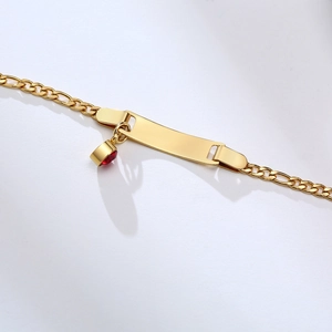 Close-up of gold stainless steel bracelet with custom curved plate and red crystal charm