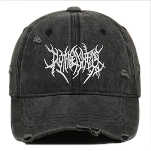 Detail of Gothic washed black baseball cap featuring white embroidery and distressed holes