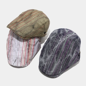 Close-up of vintage distressed striped beret hats in army green and grey cotton fabric