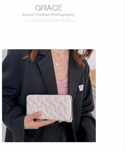 Detail view of woven texture and metal zipper on beige long PU leather clutch wallet