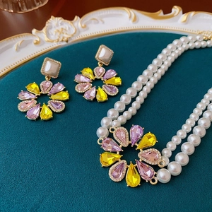 Luxuriöses Blumen-Schmuckset mit violetten Edelsteinen und doppelter Perlenkette