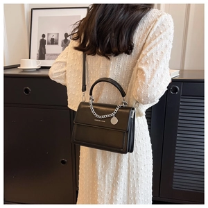 Close-up of black PU leather crossbody bag with silver chain and FASHION & BAGS logo